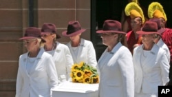 12月23日澳大利亞悉尼舉行的葬禮上，身穿白衣的葬儀人員扶抬著咖啡館經理托尼約翰遜的棺木。