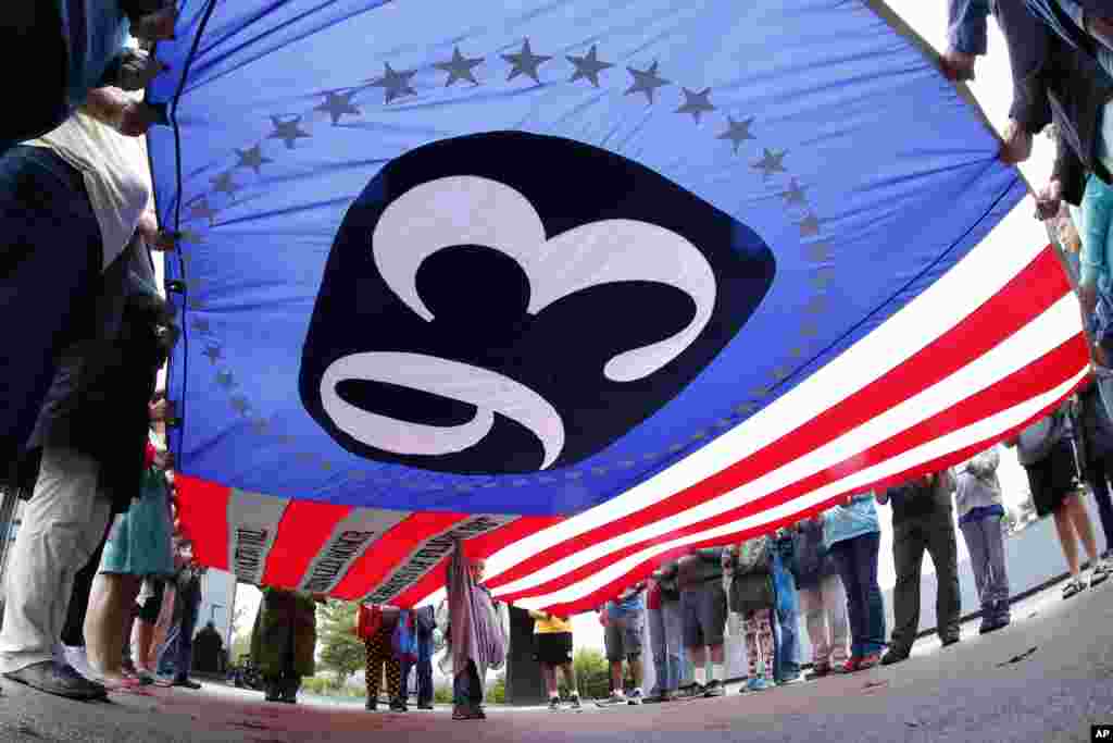 美国宾夕法尼亚州尚克斯维尔的国家纪念场，参观者举着一面巨大的旗帜，上面有&ldquo;93&rdquo;字样，纪念当年93号航班上的英烈。