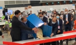 香港选管会主席冯骅(前排右二)与政制及内地事务局局长曾国卫(左二)9月19日晚在会展点票中心，监督选委会选举首个投票箱的开票过程 (美国之音/汤惠芸)