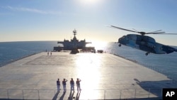FILE - This image made from a video released Jan. 13, 2021, by the Iranian Army shows a helicopter landing on the Makran logistics vessel during a navy drill. (Iranian Army via AP)