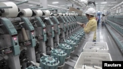 中國新疆阿克蘇雅戈爾集團的棉紡織廠工人在工作。（2015年12月1日）