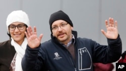 被伊朗当局释放的华盛顿邮报驻德黑兰首席记者杰森·雷载安和亲属在德国一家医疗中心前向媒体挥手致意。（2016年1月20日）