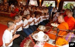 Members of Wild Boars soccer team change clothes after marking the completion of their serving as novice Buddhist monks in Mae Sai district, Chiang Rai province, northern Thailand, Aug. 4, 2018.