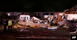 Police stand at the ruins of a hotel in El Reno, Okla., May 26, 2019, following a likely tornado touchdown late Saturday night.