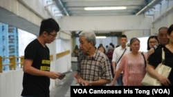 香港大學學生劉同學(左)自發在公共屋邨向街坊宣傳佔中全民投票