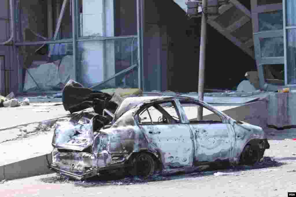 天津爆炸事故現場，核心爆炸區週圍多座居民樓窗戶被震碎，高速公路橋樑受損，多輛大貨車被炸翻，小汽車起火或被砸，多名當地居民仍逗留在事故現場。（美國之音記者東方拍攝）