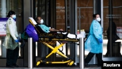 紐約大學蘭貢醫院的醫護人員正在轉移一名戴口罩的病人。（2020年5月3日）