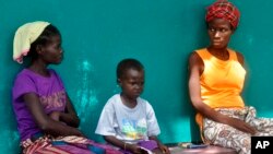 三名懷疑感染伊波拉的人坐在利比里亞首都蒙羅維亞的一家醫院前等候檢測。