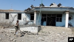 一名阿富汗的保安人员在喀布尔东部的卡车炸弹袭击事件的事发地进行检查(2015年8月6日)。
