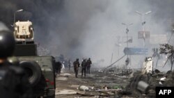 资料照：埃及安全部队驱散开罗阿巴•拉达维亚抗议营地的示威人群后站在废墟中间。（2013年8月14日） 