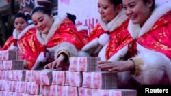 在中國杭州一個公園，工作人員在一場有獎遊戲中擺放百元鈔票（2016年1月26日）