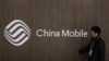 一名男子路过中国移动的标志