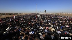 Russian President Vladimir Putin, flanked by Defense Minister Sergei Shoigu, left, and Federal Security Service Chief Alexander Bortnikov, right, arrives on a boat after inspecting battleships during a navy parade marking the Victory Day in Sevastopol, Crimea, May 9, 2104.