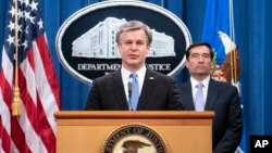 聯邦調查局局長克里斯托弗·雷在司法部舉行的網絡新聞發布會上講話，司法部助理部長約翰·德默斯站在一旁。(2020年10月28日)