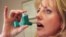 Registered nurse Darlene Martin, from Santa Monica, California, reaches for her asthma inhaler, March 1998. (file photo)