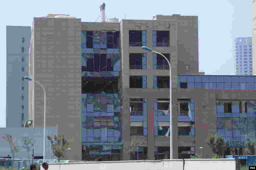 天津爆炸事故現場，核心爆炸區週圍多座居民樓窗戶被震碎，高速公路橋樑受損，多輛大貨車被炸翻，小汽車起火或被砸，多名當地居民仍逗留在事故現場。（美國之音記者東方拍攝）