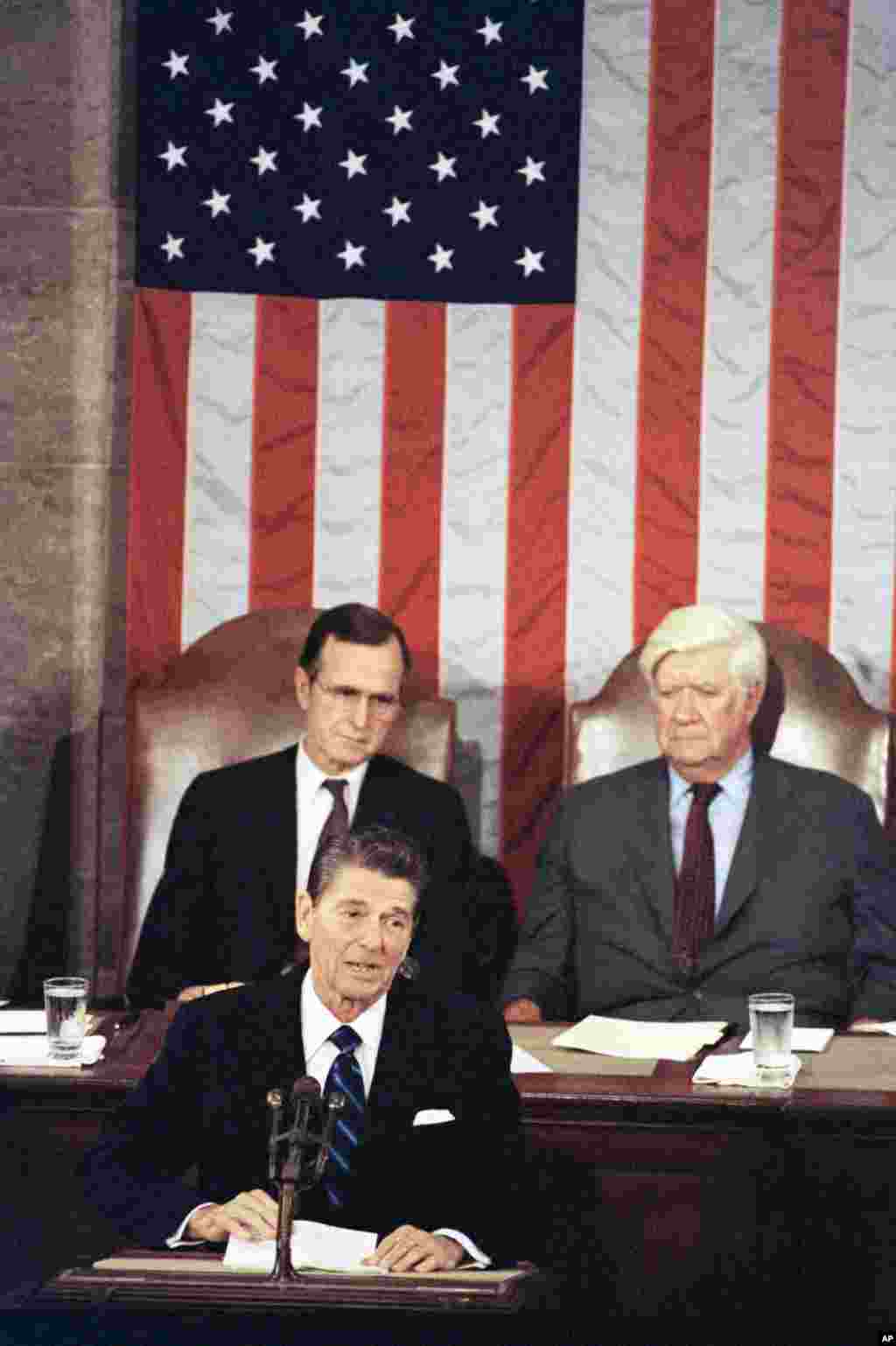 1981年4月28日，美國總統里根在國會發表講話，談經濟計劃。眾議院議長奧尼爾和副總統兼參議院議長老布殊坐在里根後面。