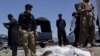 Pakistani security officials stand next to the covered body of Red Cross worker Khalil Dale in Quetta April 29, 2012.