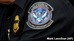 Таможенник с нашивкой Агентства таможенной и пограничной охраны США, в Международном аэропорту имени Джона Ф. Кеннеди в Нью-Йорке, 27 октября 2017 года,