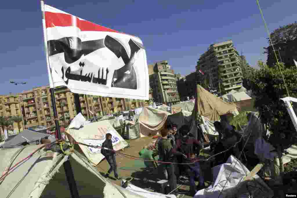 2012年12月10日，反穆尔西的抗议者坐在埃及解放广场帐篷外，头顶旗帜上的口号是：&ldquo;不要这部宪法！&rdquo;