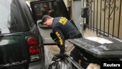  警方调查人员从旧金山中国城致公堂总堂取出大包东西。（2014年3月26日）