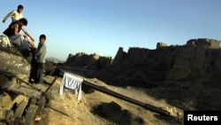 Afghan men sit on an abandoned tank after a swim in the city of Ghazni, southwest of Kabul, August 20, 2007. (Click to Expand)
