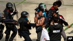 泰國一名反政府抗議者(中)在曼谷體育館發生衝突時被警察驅逐。(2013年12月26日照片)