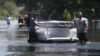 People use an air mattress to float possessions out of a flooded area of Port Arthur, Texas, Aug. 31, 2017. Health officials warn people to avoid floodwaters, which could be contaminated, electrified or hiding sharp objects.