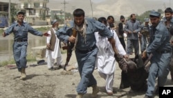 阿富汗警察在巴格蘭省議會大樓外的自殺炸彈襲擊現場抬走傷員。（2013年5月20日）
