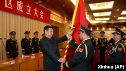 中国国家主席习近平（左前）在北京举行的中国人民解放军战区成立大会上向五大战区授予军旗。（2016年2月1日）