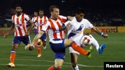 孟买市FC足球队的迭戈•费尔南多•纳达亚（右）与加尔各答竞技队的何塞•米格尔•冈萨雷斯•雷在加尔各答盐湖体育场举行的印度超级联赛开场赛中争抢。（2014年10月12日）
