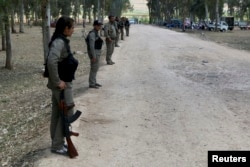 FILE - Kurdish Democratic Union Party (PYD) members stand guard during a Labor Day celebration in Efrin, Syria, May 1, 2014