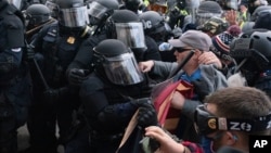 身穿防暴服的國會警察試圖阻止示威者進入國會大廈。(2021年1月6日)