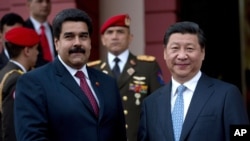 2014你7月20日中国国家主席习近平（右）在访问委内瑞拉时和委内瑞拉总统马杜罗握手