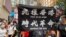 参与5-24港岛反恶法游行的人士高举反送中运动的”光复香港、时代革命”标语，高举这面标语旗帜在港版中国国家安全法实施后，可能会触犯相关法例。 (美国之音汤惠芸拍摄)