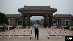 北京郊區秦城監獄入口處,一名女警員試圖阻止記者拍照。