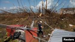 A member of the Canadian Burnaby Firefighters Search & Rescue Task Force searches for victims after Hurricane Dorian hit the Abaco Islands in Marsh Harbour, Bahamas, Sept. 11, 2019.