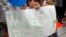 Shua Rich, age 6, holds his sign as he protests with his mother during a rally against U.S. immigration policies outside an office for Rep. Kevin Yoder, June 22, 2018, in Overland Park, Kan.