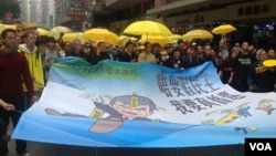 民主派元老李柱铭（中间黄衣举伞者）参加2/1民主游行（美国之音海彦拍摄）