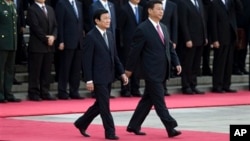 2013年6月19日，中国国家习近平陪同来访的越南国家主席张晋创（左）在北京人民大会堂检阅三军仪仗队