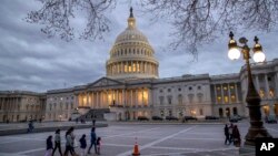 People walk by the U.S. Capitol in Washington, Jan. 21, 2018.