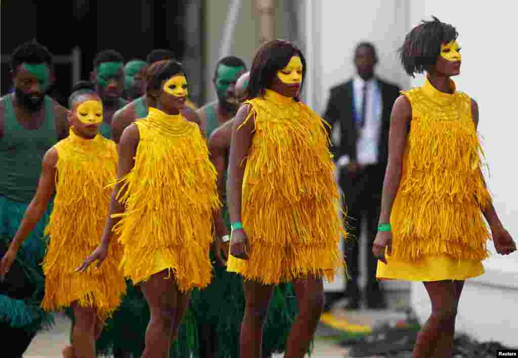 A woman stands along the side of a road on the outskirts of the town of Tal Tamr near the Syrian Kurdish town of Ras al-Ain along the border with Turkey in the northeastern Hassakeh province with the smoke plumes of tire fires billowing in the background to decrease visibility for Turkish warplanes.