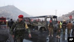 在喀布尔一处自杀炸弹袭击现场，阿富汗士兵站在被炸毁的汽车周围。