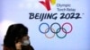 一名女子走过北京冬奥会的大幅广告。（2021年12月9日）