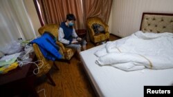 一名從海外回到中國的留學生集中在山西省太原市的一家旅館房間裡隔離。（2020年3月17日）