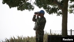 2014年9月1日联合国观察部队成员在叙利亚通过望远镜观察以色列占领的戈兰高地