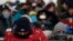 Spectators, with their faces covered, waiting for the start of the women's slopestyle qualifications at Phoenix Snow Park at the 2018 Winter Olympics in Pyeongchang, South Korea, Feb. 11, 2018.