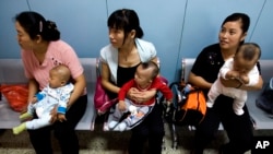 在为农民工提供母婴检查的北京朝阳区十八里店乡医院，中国妇女抱着孩子等着看医生。（2007年9月5日资料照）