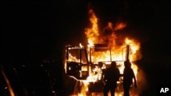 埃及示威者星期五在開羅的解放廣場附近焚燒警車，而安全部隊向成千上萬的支持民
主的示威者發射催淚瓦斯