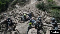 中国武警士兵在四川阿坝州九寨沟县附近发生强烈地震后抢救幸存者。（2017年8月9日）